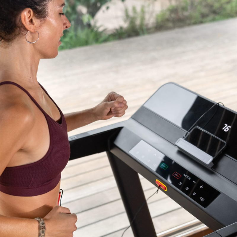Cinta de Correr Plegable Fitfiu Fitness MC-560, mujer corriendo viendo el centro de mandos